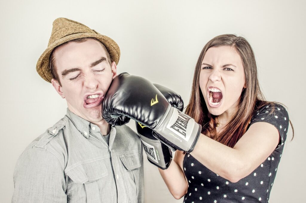 Vrouw slaat een man met boxhandschoen