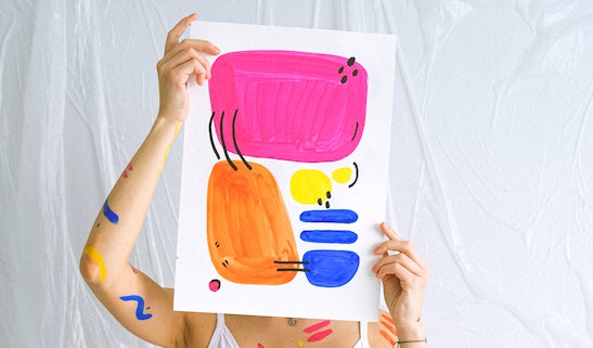 Afbeeldingen van een vrouw die haar gelaat bedekt door er een kunstwerk voor te houden.
