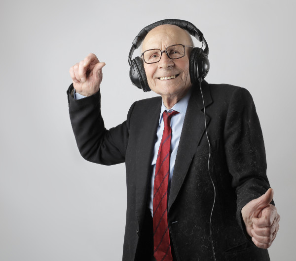 Oude man met hoofdtelefoon, genietend van het leven